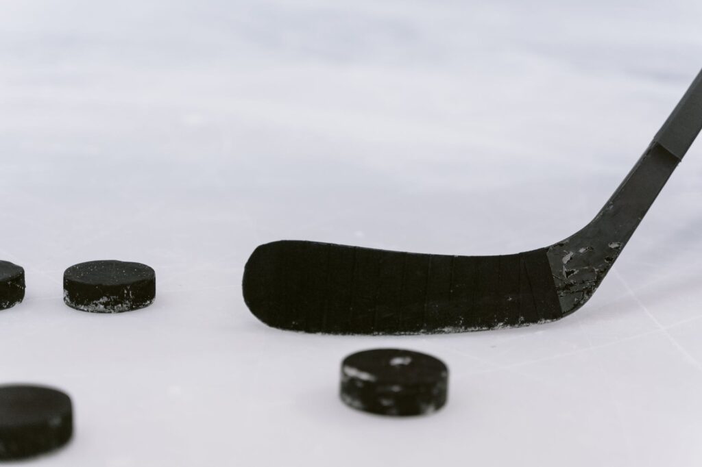 close up shot of a hockey puck and hockey stick