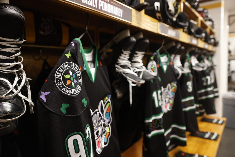 Mental Health Awareness jerseys hang in the Chicago Wolves locker room for the 2022-23 season.